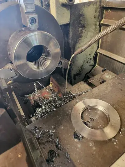 Lathe turning threaded steel fitting